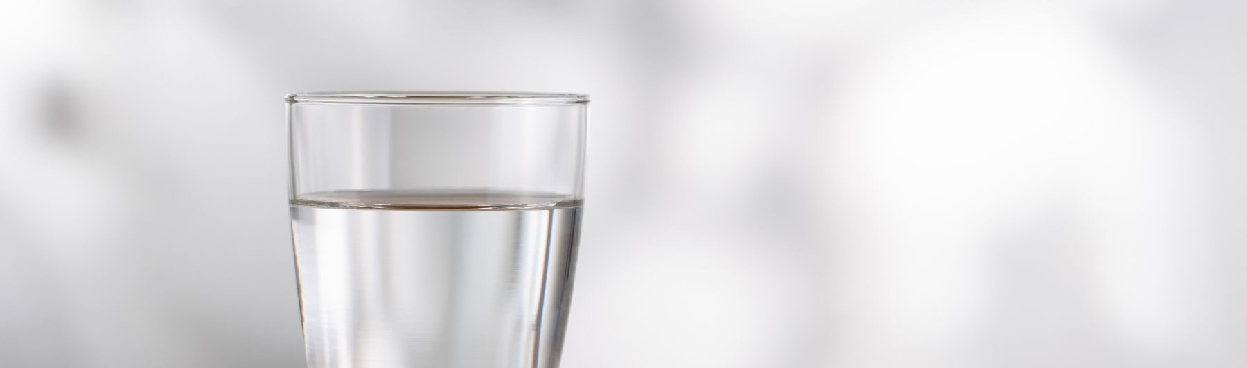 closeup of a cup of water on a blank blurred background