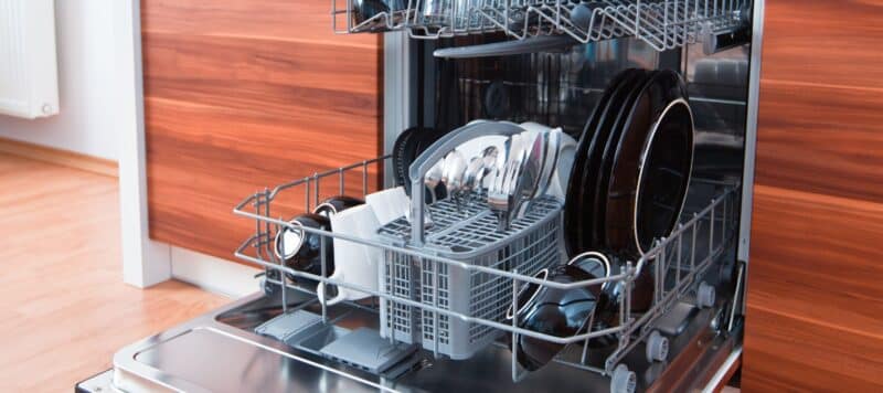 dishes neatly placed in a dishwasher machine ready to be washed